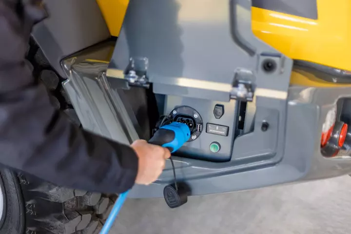 Der Ladepunkt des Radladers 5065e befindet sich durch eine Klappe geschützt an der Fahrzeugaußenseite.